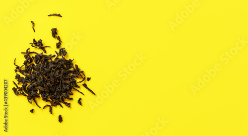 Loose black tea ( Assam variety ) on yellow board, view from above space for text right side