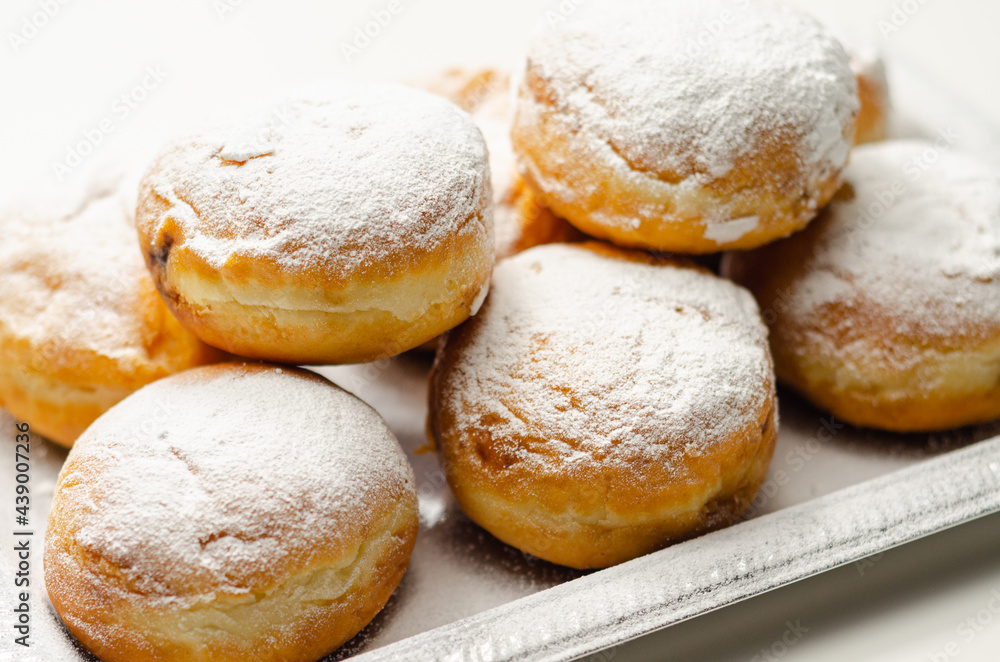 Berliner Pfannkuchen, a German donut, traditional yeast dough deep fried filled with chocolate cream and sprinkled with powdered sugar