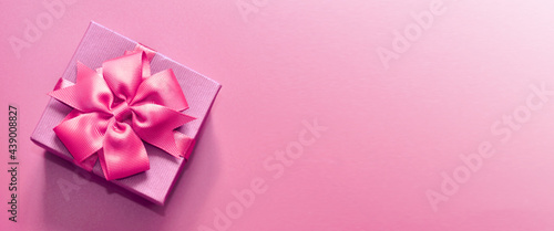 Holiday concept banner with hand made gift box  bow on a purple background with space for text.