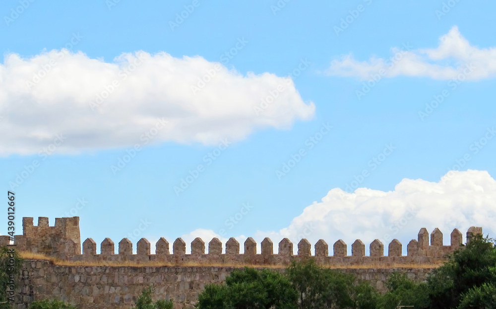 Fluffy clouds over the battlements of the wall of Ávila, in Spain.  