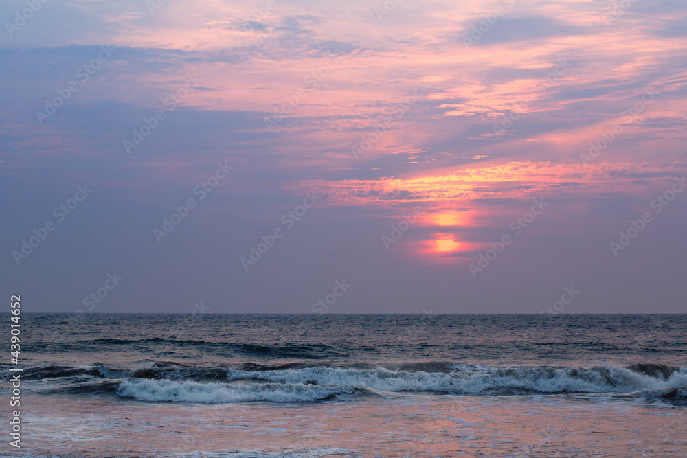 Beautiful pink sunset by the raging ocean