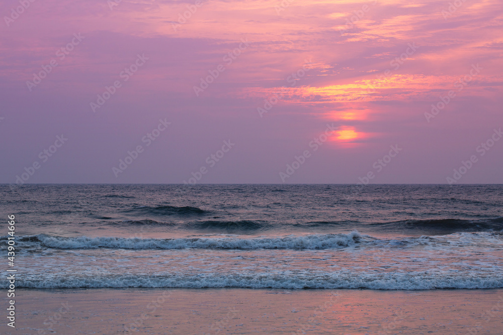pink sunset by the raging ocean