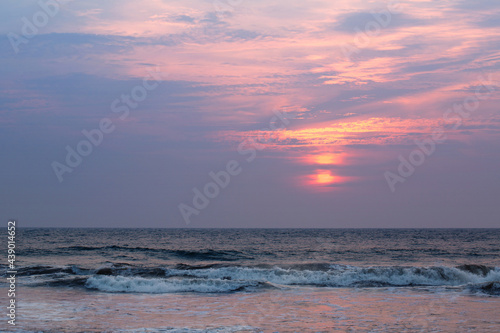 Beautiful pink sunset by the raging ocean