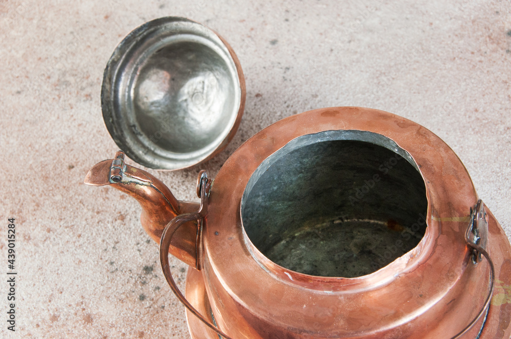 Old copper kettle on concrete background. Old copper kettle on concrete background.