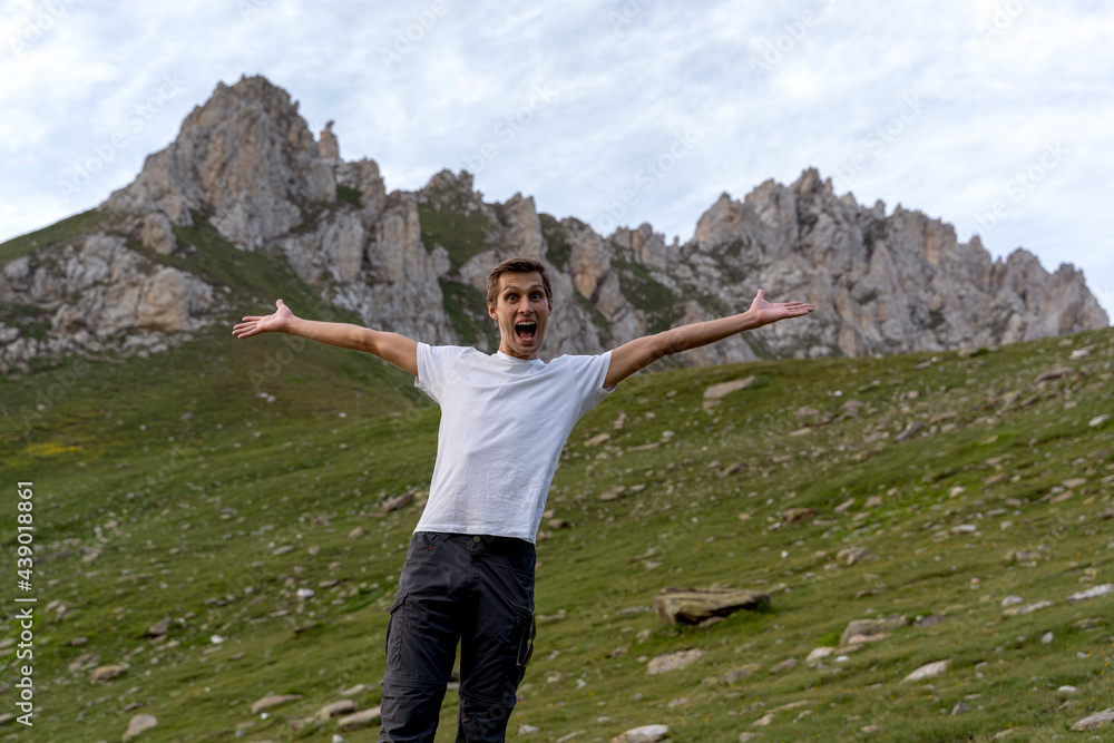 Happy young man celebrate for reaching the top of the mountain. .Mountain range in the background