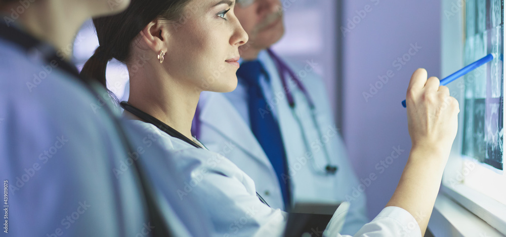 Group of doctors examining x-rays in a clinic, thinking of a diagnosis
