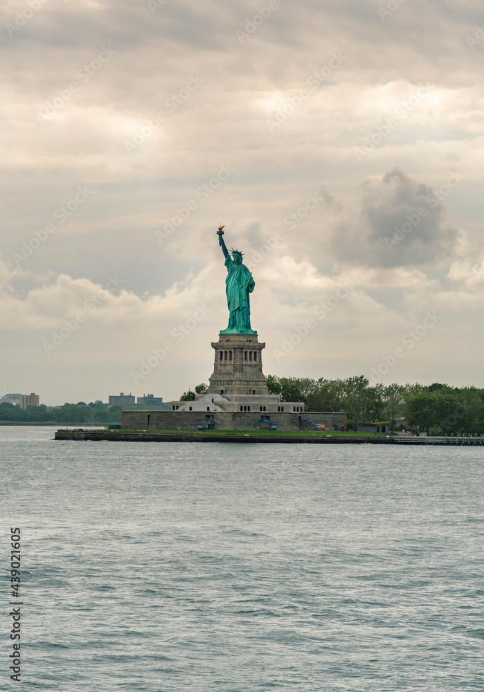 Ferry and Statue of Liberty , world famous travel destination composed with beautiful  sky and clouds.