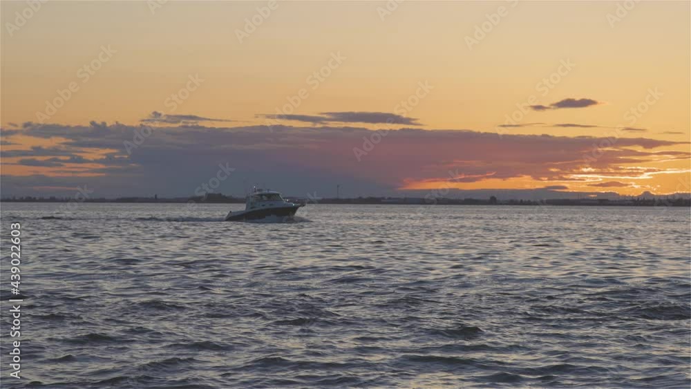 White Rock, Greater Vancouver, British Columbia, Canada. Colorful and Vibrant View of a cloudy and colorful sunset over the Pacific Ocean Coast. Boat on the Horizon. Slow Motion White Rock, Greater Vancouver, British Columbia, Canada. Colorful and Vibrant View of a cloudy and colorful sunset over the Pacific Ocean Coast. Boat on the Horizon. Slow Motion