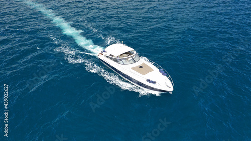 Aerial drone photo of small luxury yacht cruising in deep blue sea near Aegean island, Greece © aerial-drone