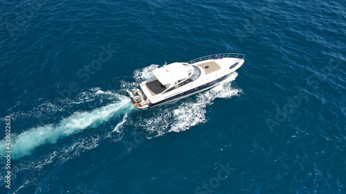 Aerial drone photo of small luxury yacht cruising in deep blue sea near Aegean island, Greece © aerial-drone