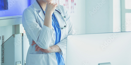 Fotografie Young woman medic in white uniform standing in clinic's office