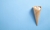  Ice cream in waffle cone on blue background.
