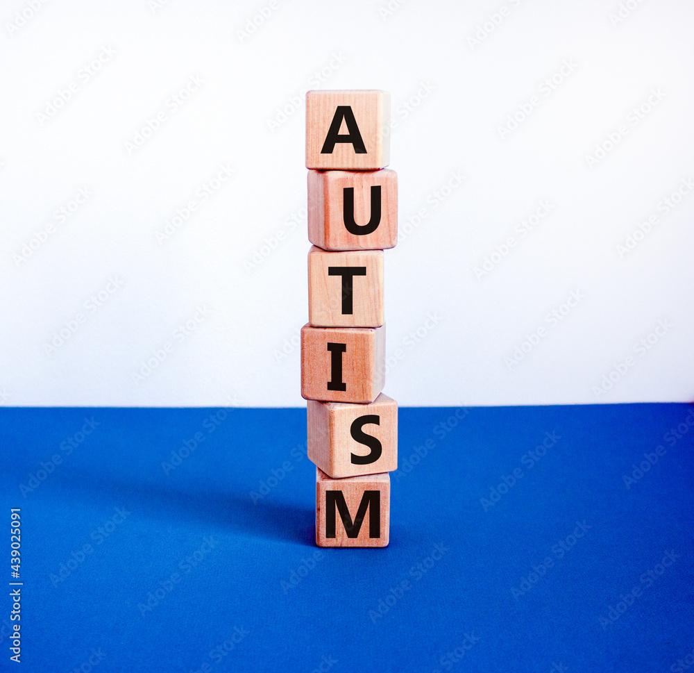 Autism symbol. Wooden cubes with the word 'autism'. Beautiful white and blue background. Psychological, medical, business and autism concept. Copy space. Autism symbol. Wooden cubes with the word 'autism'. Beautiful white and blue background. Psychological, medical, business and autism concept. Copy space.