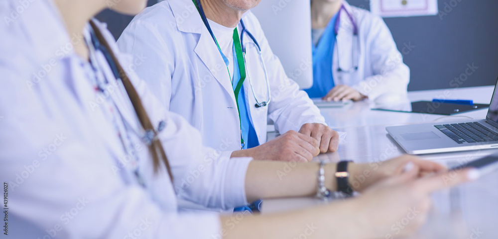 Serious medical team using a laptop in a bright office Serious medical team using a laptop in a bright office