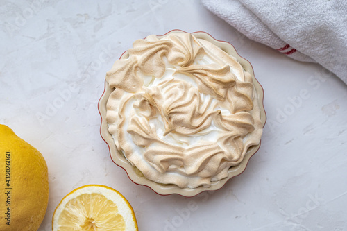 Lemon Merinque Tartlette flat lay with lemons and a dish towel photo