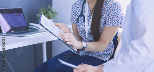 Two doctors speaking in a bright office