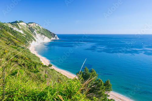 Fototapeta Naklejka Na Ścianę i Meble -  The beach of Mezzavalle view from above unique bay in Conero natural park dramatic coast headland rock cliff adriatic sea Italy turquoise transparent water