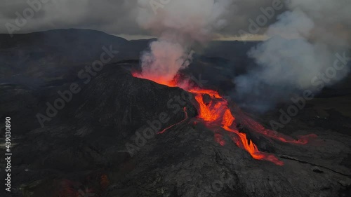 Aerial footage of an icelandic volcano erupting in 2021 in Reykjanes peninsula, shot at dusk with contrast with black lava landscape and red hot lava. High quality 4k footage