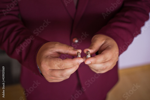 A man holds wedding rings in his hands 2795.