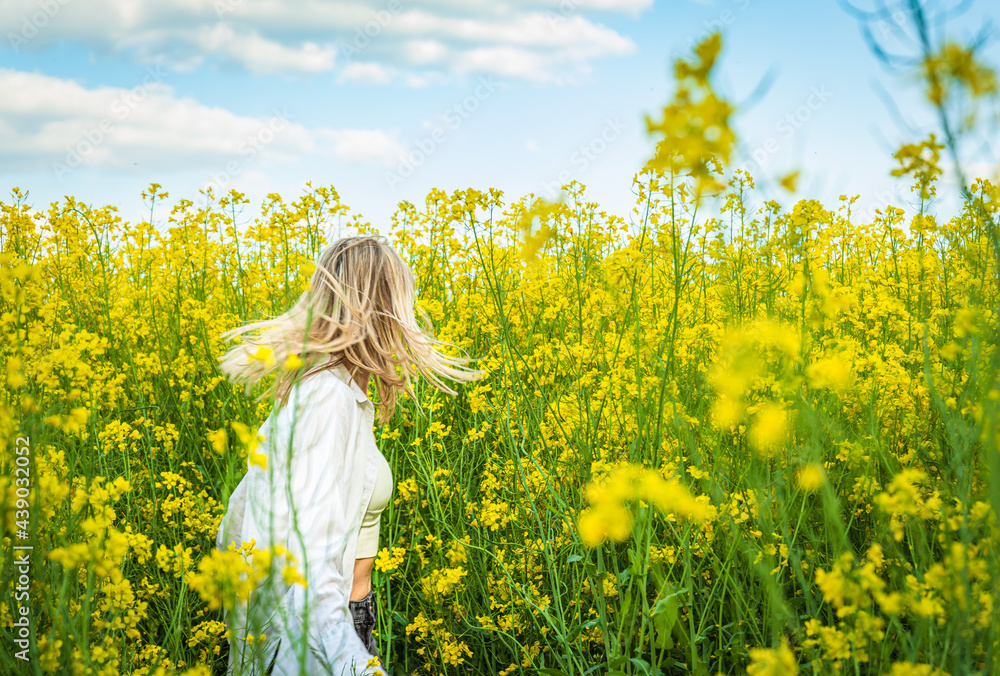 The girl is spinning among the blooming rapeseed The girl is spinning among the blooming rapeseed