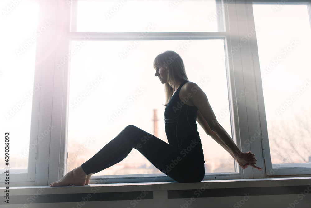 Young attractive smiling woman practicing yoga, working out, wearing sportswear, bra, home Young attractive smiling woman practicing yoga, working out, wearing sportswear, bra, home