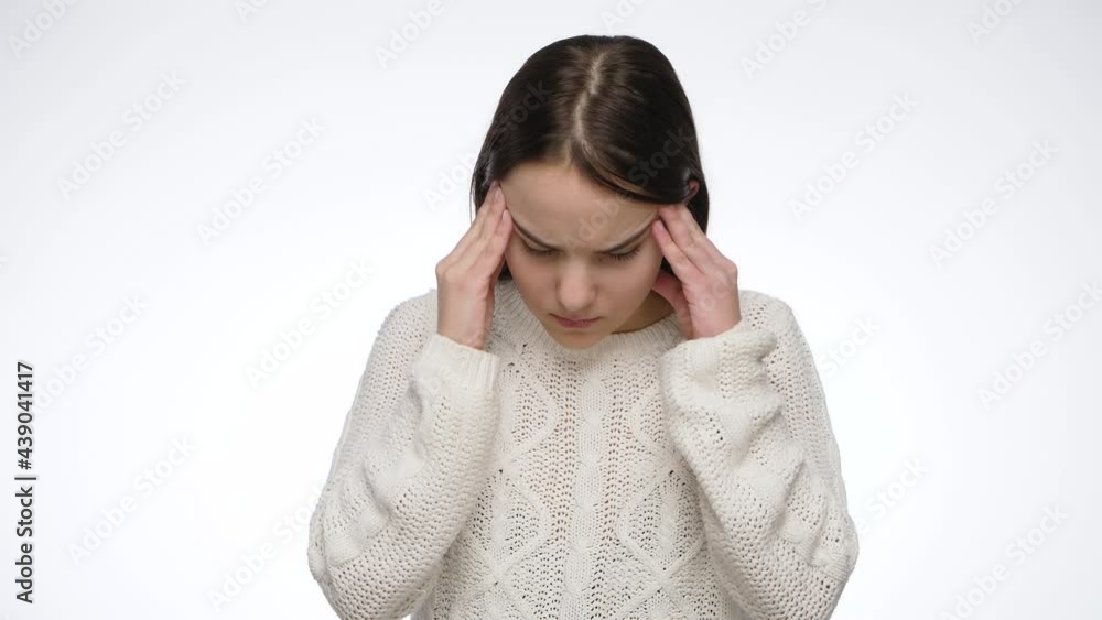Studio portrait of young girl suffering from headache and rubbing temples. Studio portrait of young girl suffering from headache and rubbing temples.