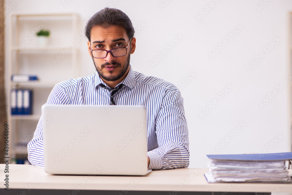 Young male employee working in the office Young male employee working in the office