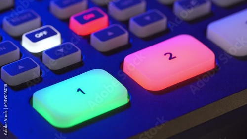 A close-up image of the video switcher shows alternating red and green lights on the buttons for cameras 1 and 2, indicating the operation of both cameras.