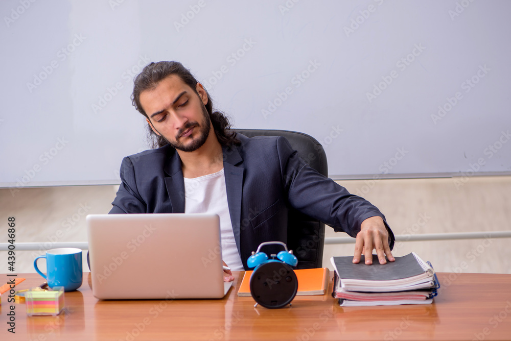 Young male teacher in the classroom Young male teacher in the classroom