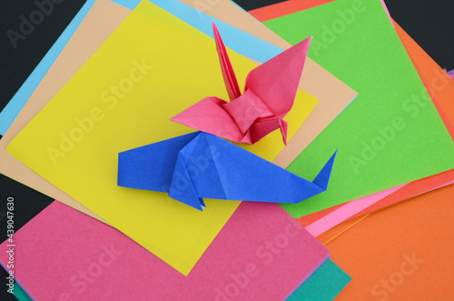 沢山の折り紙と、折り紙で折った鶴と魚。