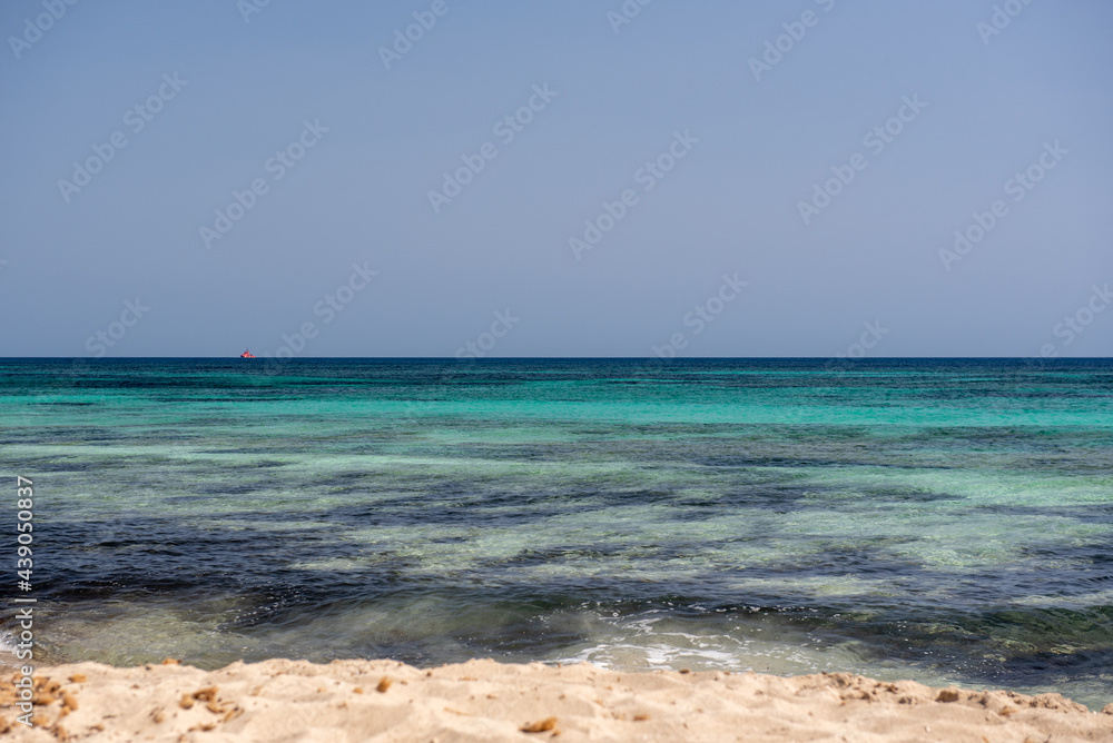 Wonderful turquoise water of Migjorn beach in Formentera in Spain..