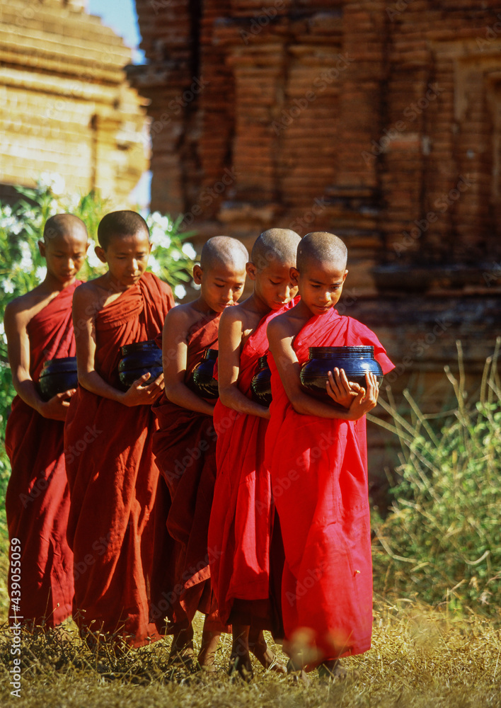 Myanmar, Bagan, Mandalay Division, Buddhist monks holding bowls during morning alms Myanmar, Bagan, Mandalay Division, Buddhist monks holding bowls during morning alms