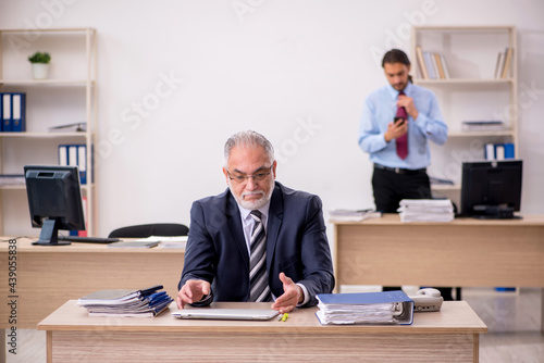 Old male boss and young employee working in the office © Elnur