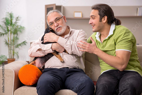 Two men with dog at home