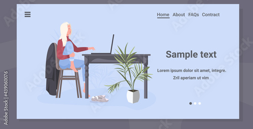 young woman freelancer sitting at workplace working on laptop coronavirus pandemic quarantine