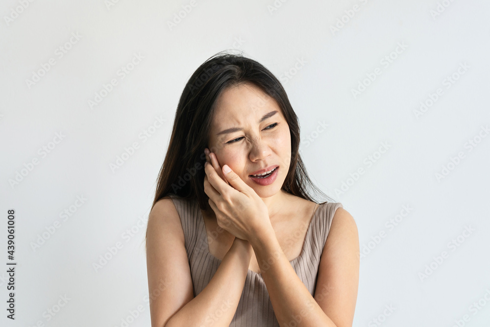 Asian woman feeling teeth pain. Closeup of sad girl suffering from toothache. Beautiful female feeling painful toothache on white background. Dental health and care, teeth problem concept. Copy space Asian woman feeling teeth pain. Closeup of sad girl suffering from toothache. Beautiful female feeling painful toothache on white background. Dental health and care, teeth problem concept. Copy space