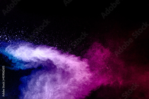 Pink blue dust particles splash on black background.Pink blue powder splash.