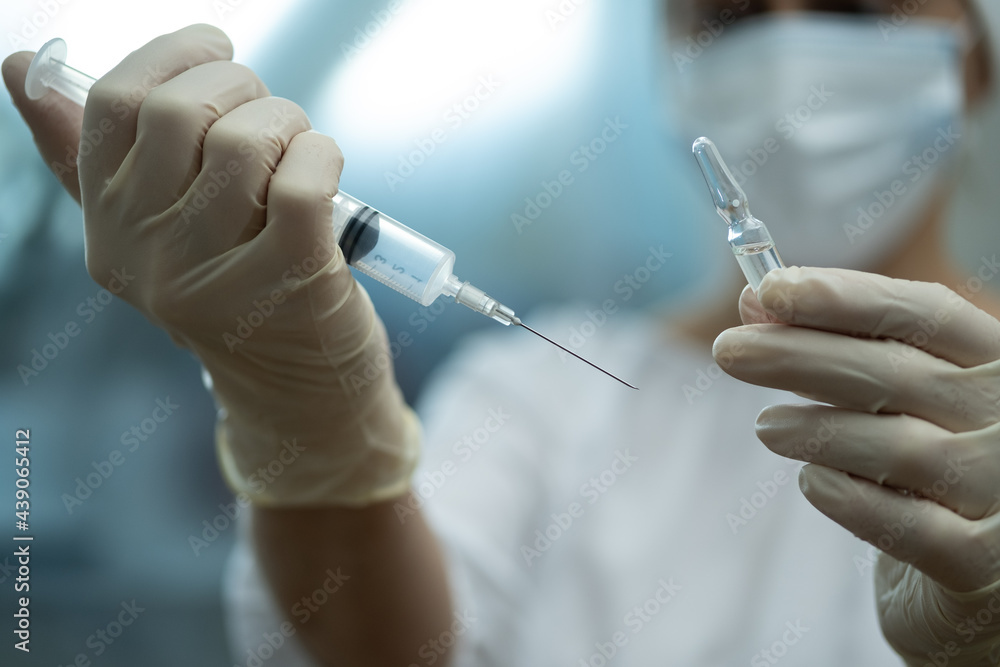 Ampoule and syringe in the doctor's hand. Ampoule and syringe in the doctor's hand.