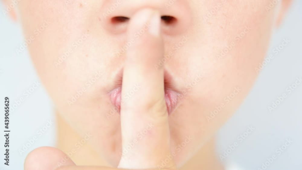 Boy shows silence gesture with finger near his lips Boy shows silence gesture with finger near his lips