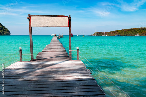 Landscape of seascape with wooden bridge in the sea at Koh Kood is a tropical island with emerald green water and beautiful beaches amidst clear blue sky. © shutterbumpkin
