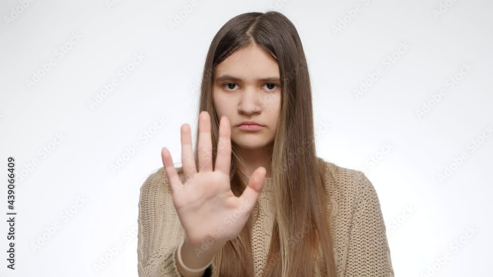 Stop or no sign. Girl showing refuse or deny gesture with hand over white studio background Stop or no sign. Girl showing refuse or deny gesture with hand over white studio background