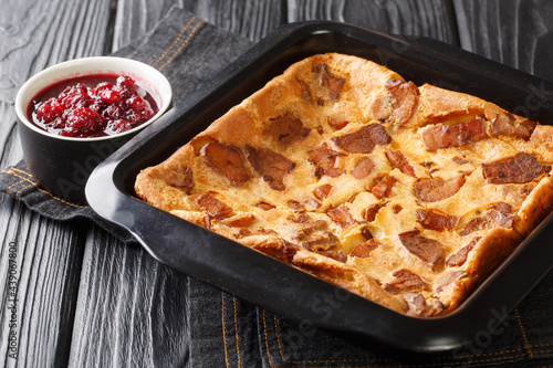 Swedish food hot pancake served with lingonberry jam close-up in a baking dish on the table. horizontal photo