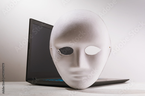 Mask and laptop on the table close-up, concept on the topic of anonymity on the Internet