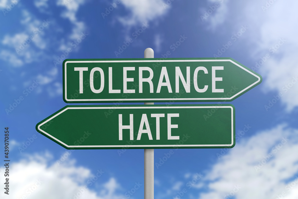 Tolerance or Hate - green road sign on sky background Tolerance or Hate - green road sign on sky background