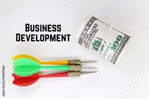arrows, a roll of paper money and the word business development © Fauzi