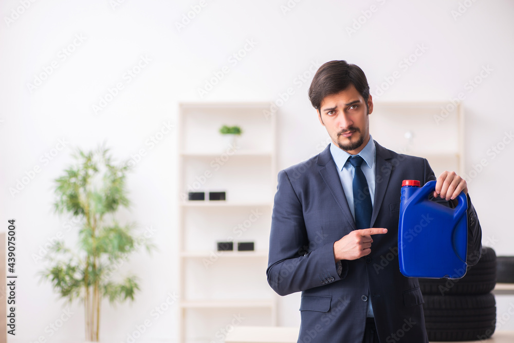 Young man car equipment seller holding jerrycan Young man car equipment seller holding jerrycan