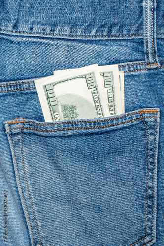 Dollar bills sticking out of the back pocket jeans