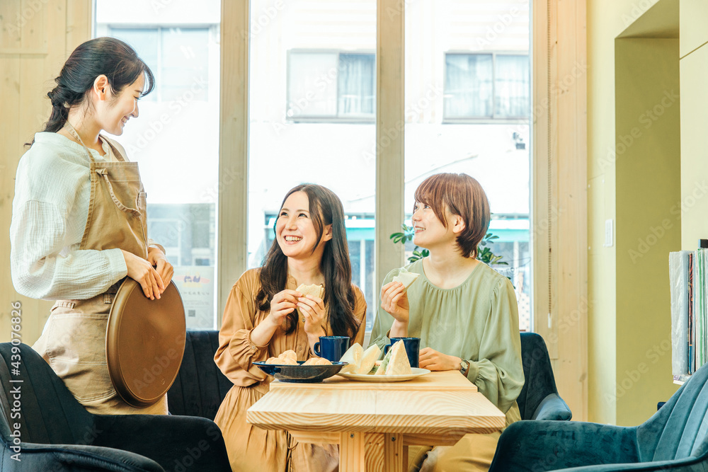レストランで食事する女性とホールスタッフ
レストランで食事する女性とホールスタッフ