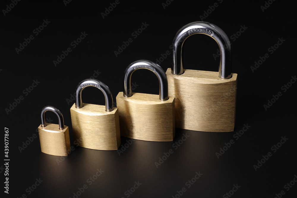 Various brass padlocks of various sizes with black background Various brass padlocks of various sizes with black background