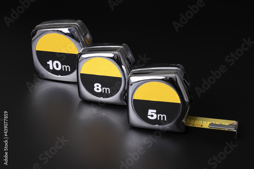 Flexometers or measuring tapes on black background photo
